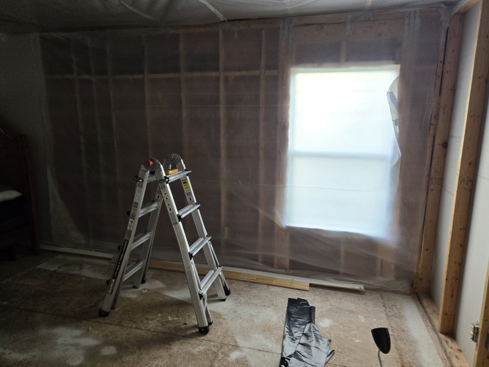 Interior prepared with containment sheeting during reconstruction after water damage